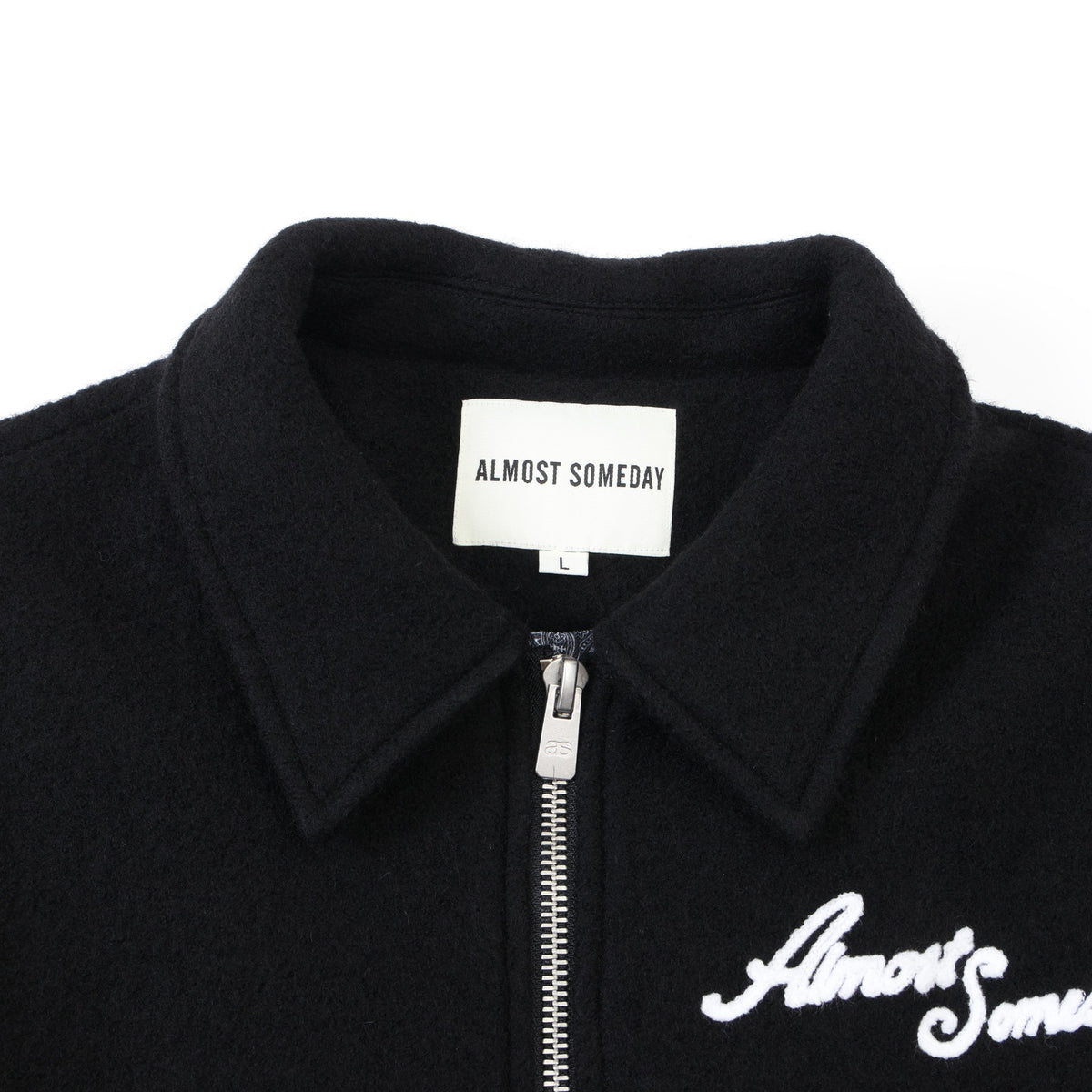 Saint Cropped Wool Jacket – Black – Close-up of pointed collar, interior brand label, and metal zipper pull
