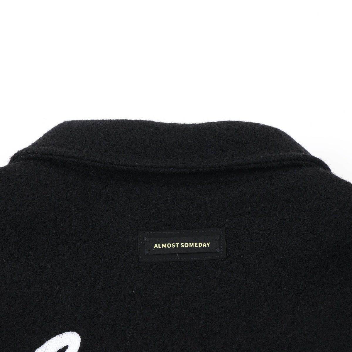 Saint Cropped Wool Jacket – Black – Close-up of back collar and black Almost Someday brand patch