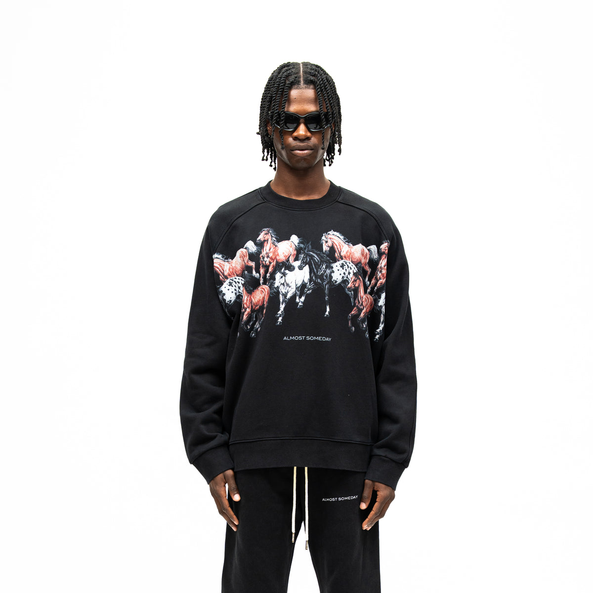 Smoke Crewneck – Black – Front view on model showing running horses graphic, Almost Someday branding, and ribbed cuffs and hem