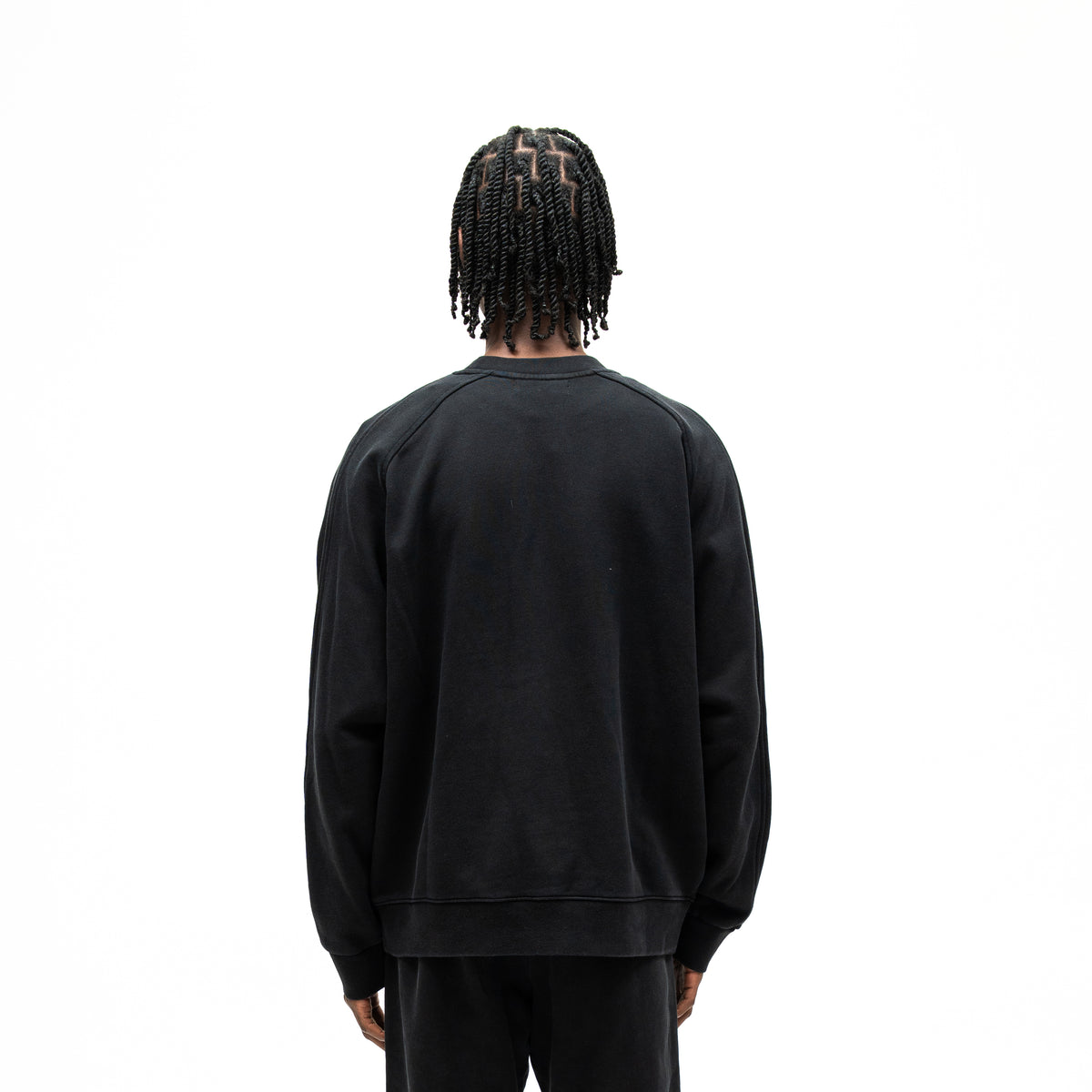 Smoke Crewneck – Black – Back view on model showing plain black back, raglan shoulder seams, and ribbed hem