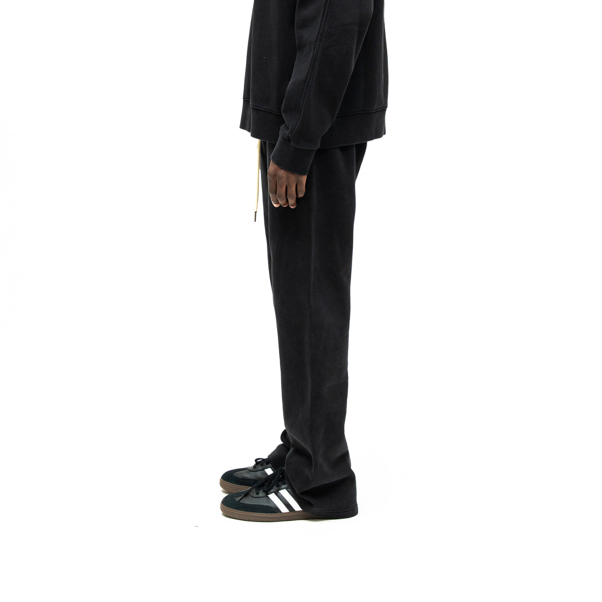 Smoke Flare Bottoms – Black – Side view on model styled with black crewneck, showing long leg and flared hem