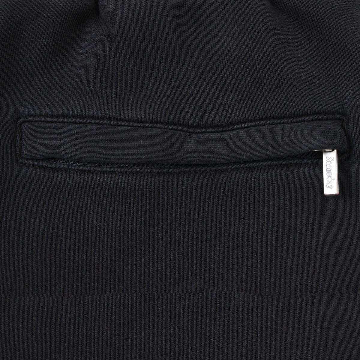 Smoke Flare Bottoms – Black – Close-up of rear welt pocket and silver-tone Someday logo tab
