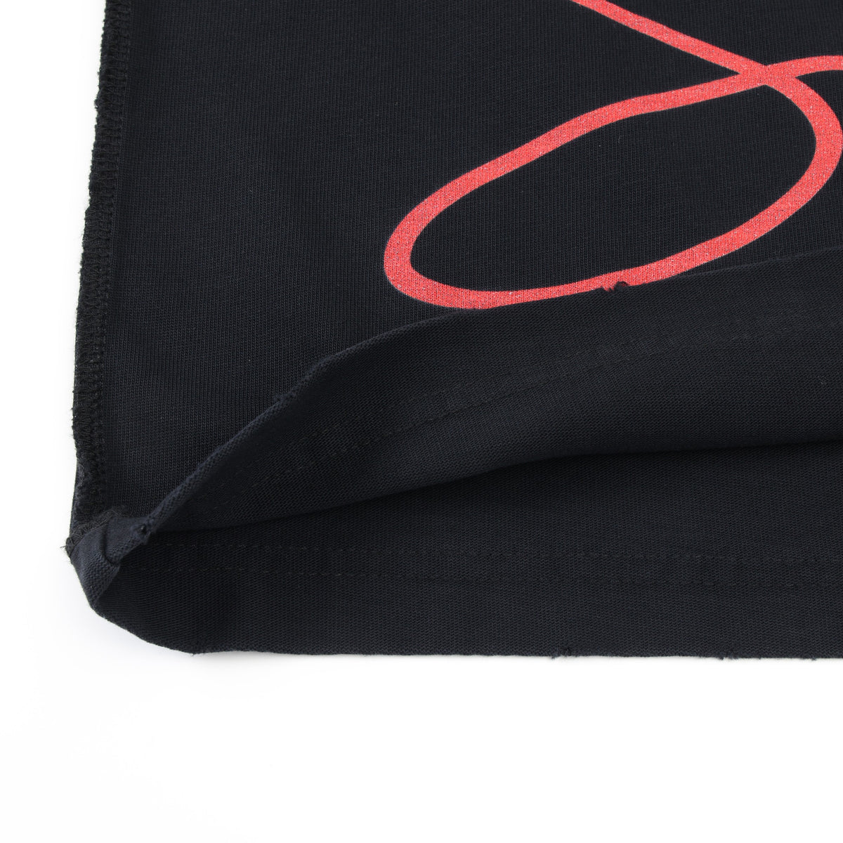 Smoke Tee – Black – Close-up of folded hem showing inside fabric and partial red script