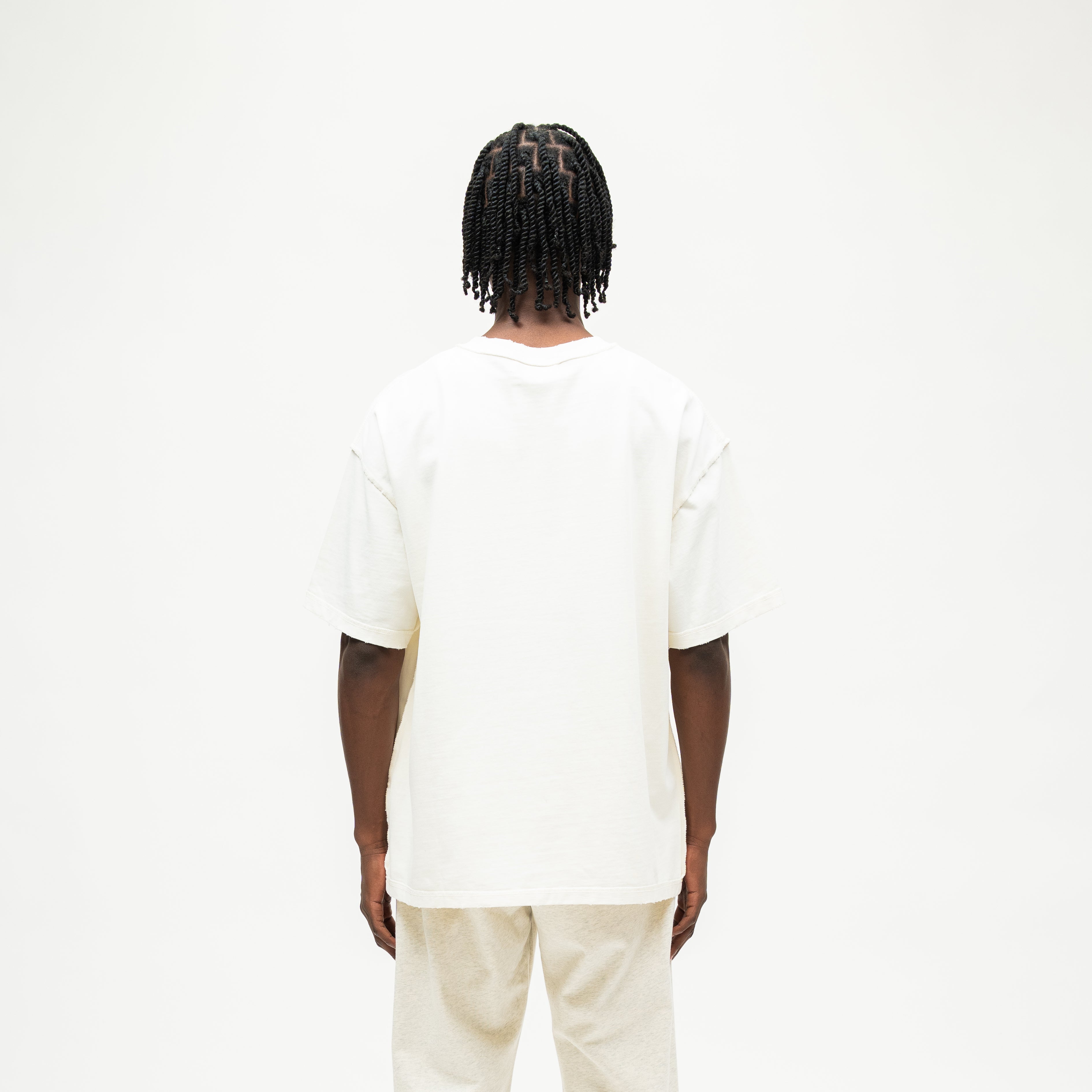 Smoke Tee – Cream – Back view on model showing plain cream back and relaxed silhouette