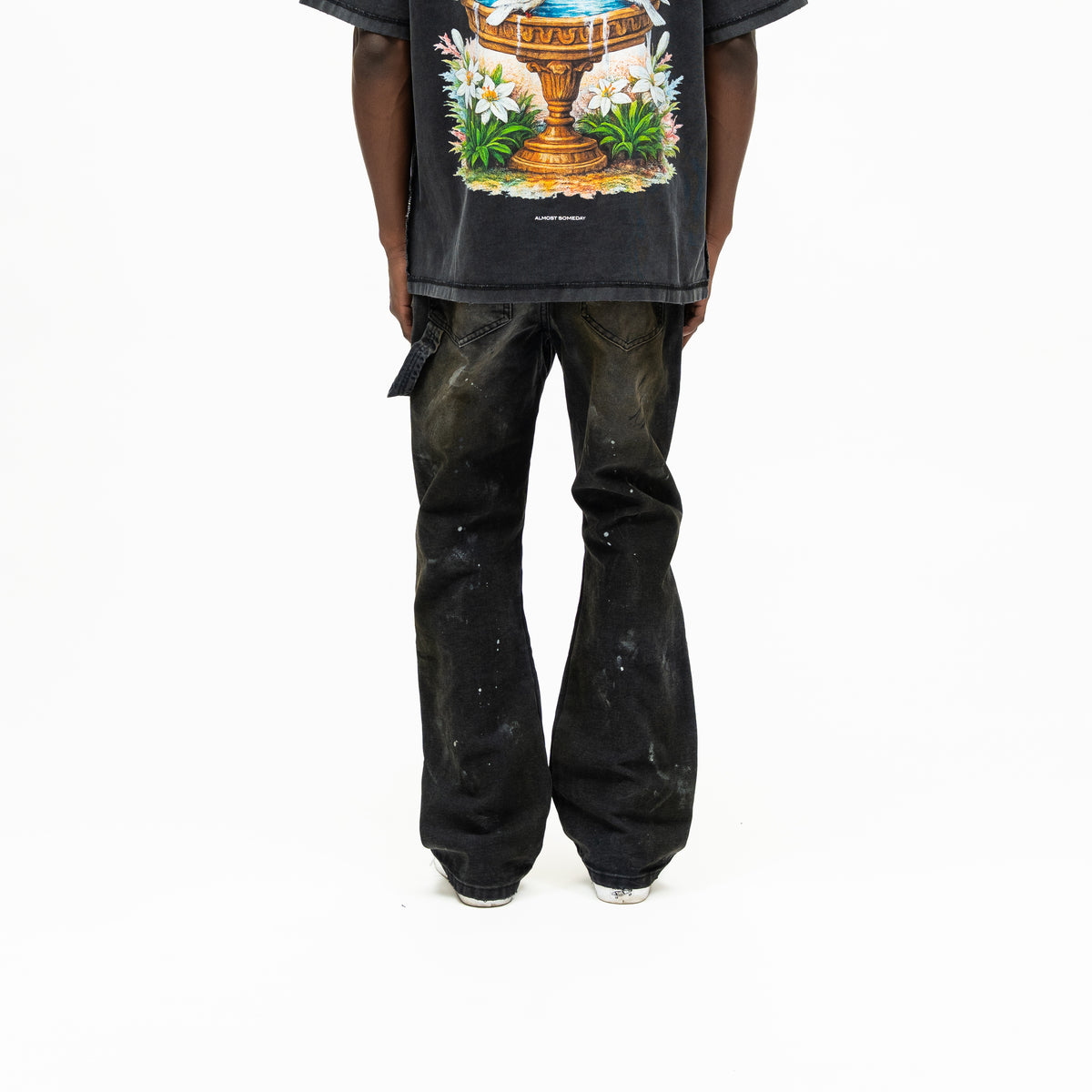 Spade Pants – Black – Back view on model showing rear patch pockets, utility loop, paint splatters, and wide legs