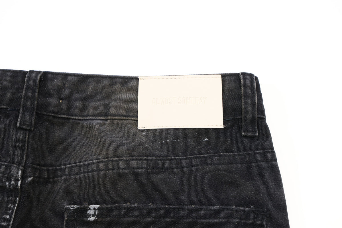 Spade Pants – Black – Close-up of cream rectangular waistband patch, belt loops, and back yoke seam