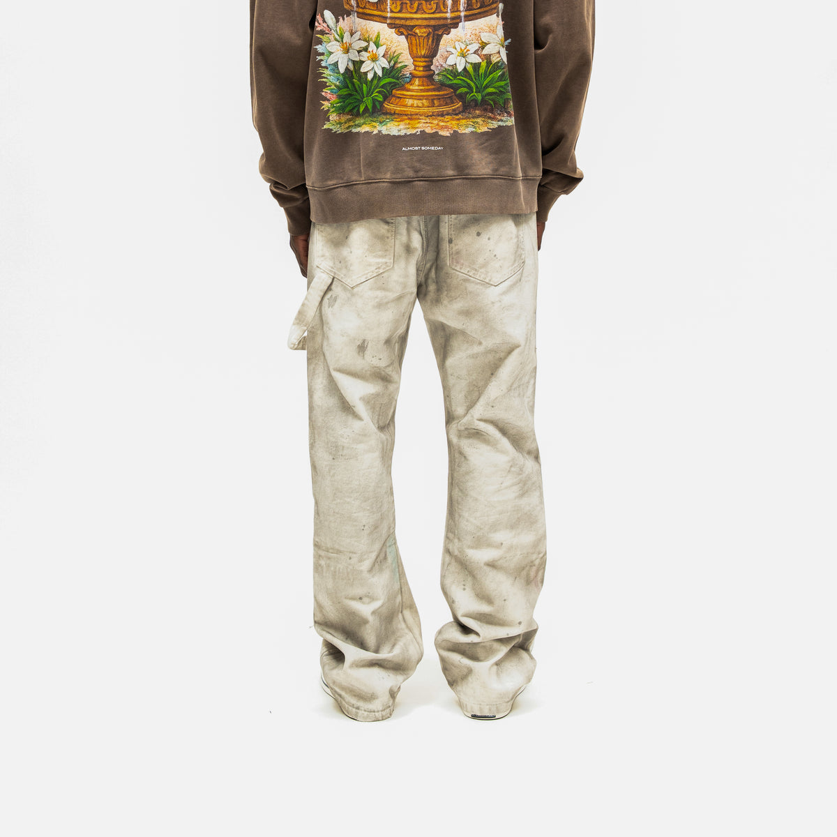 Spade Pants – Cream – Back view on model styled with brown graphic hoodie, showing rear patch pockets and wide legs